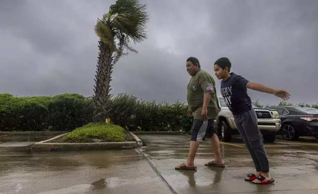 Lazaro Cardoso, 11, leans far into the powerful winds coming from the eye wall of Hurricane Francine as he and his dad, Hugo Gonzales, stay at a hotel Wednesday, Sept. 11, 2024, in Houma, La., that was being powered by a generator. The family lives not far from the hotel but they decided to stay at it since they said they always lose power during powerful storms. (Chris Granger/The Times-Picayune/The New Orleans Advocate via AP)