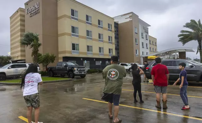 Hotels guests at the Fairfield by Marriott Inn &amp; Suites step out to look at some of the damage, top center, to the hotel as the eye of Hurricane Francine moves over the area causing a short respite in the rain, Wednesday, Sept. 11, 2024, in in Houma, La. (Chris Grange/The Times-Picayune/The New Orleans Advocate via AP)