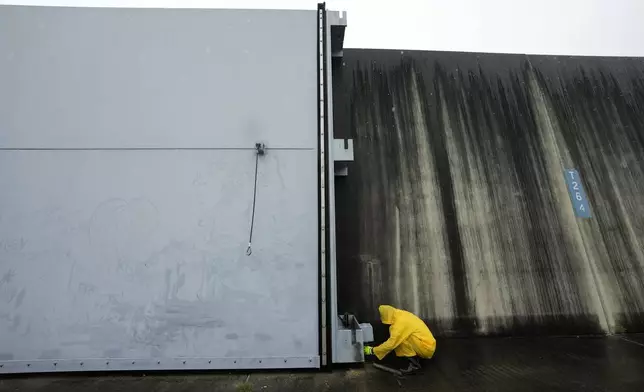 Workers from the Southeast Louisiana Flood Protection Authority-West close floodgates along the Harvey Canal, just outside the New Orleans city limits, in anticipation of Tropical Storm Francine, in Harvey, La., Tuesday, Sept. 10, 2024. (AP Photo/Gerald Herbert)