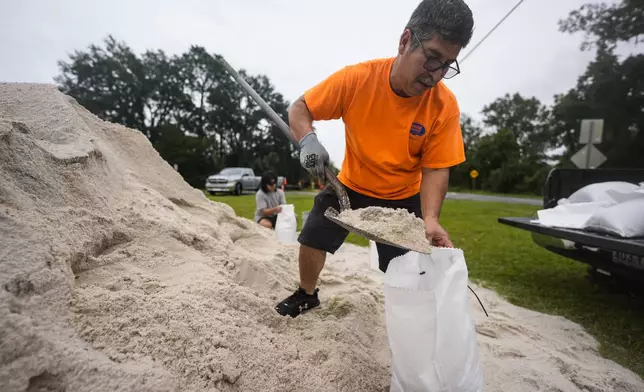 Jose Gonzales and his son Jadin Gonzales, 14, fill sand bags ahead of Hurricane Helene, expected to make landfall Thursday evening, Thursday, Sept. 26, 2024, in Clyattville, Ga. (AP Photo/Mike Stewart)