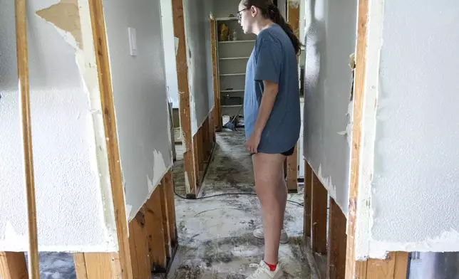 Alexis Dibuono stands in her hallway as she takes in the salvage work that needs to be done to her flood damaged home, Friday, Sept. 13, 2024, in Norco, La., two days after Hurricane Francine swept through the area. (Chris Granger/The Times-Picayune/The New Orleans Advocate via AP)