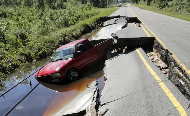 A pickup truck sits in a washed out section of road on Old Ocean Highway in Supply, N.C., Tuesday, Sept. 17, 2024. (AP Photo/Chris Seward)