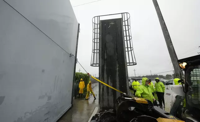 Workers from the Southeast Louisiana Flood Protection Authority-West close floodgates along the Harvey Canal, just outside the New Orleans city limits, in anticipation of Tropical Storm Francine, in Harvey, La., Tuesday, Sept. 10, 2024. (AP Photo/Gerald Herbert)