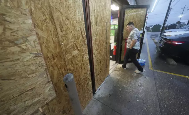 Oscar Torres, of Morgan City, enters a gas station that is boarded up in anticipation of Hurricane Francine, in Morgan City, La., Wednesday, Sept. 11, 2024. (AP Photo/Gerald Herbert)