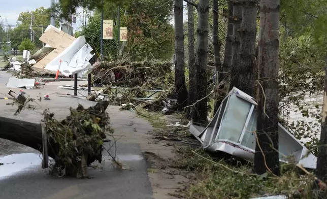 Flood debris along the Pigeon river left by tropical depression Helene is seen in Newport, Tenn., Saturday, Sept. 28, 2024. (AP Photo/George Walker IV)