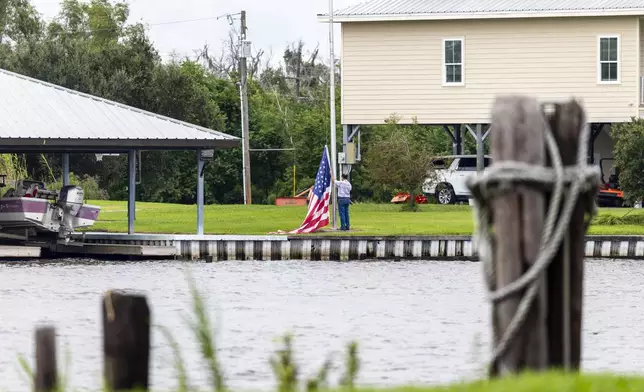 An flag is taken down off a pole as residents prepare for the arrival of Hurricane Francine along the Louisiana coast on Monday, Sept. 9, 2024, in Lafitte, La. (Chris Granger/The Times-Picayune/The New Orleans Advocate via AP)