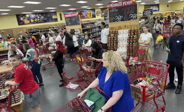 Shoppers in a suburb of New Orleans gather food supplies at a grocery store, Monday, Sept. 9, 2024. (AP Photo/Jack Brook)