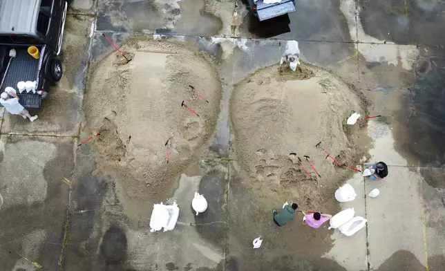 St. Bernard Parish residents fill sandbags in the old Kmart/Sears parking lot ahead of Tropical Storm Francine, Monday, Sept. 9, 2024, in Chalmette, La. (David Grunfeld/The Times-Picayune/The New Orleans Advocate via AP)