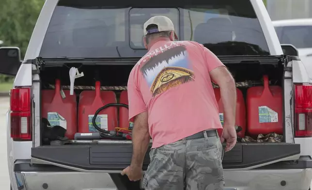 Steve Pete filled up gas containers to give to neighbors and the elderly if they need it ahead of Tropical Storm Francine in Violet, La. Monday, Sept. 9, 2024. (David Grunfeld/The Times-Picayune/The New Orleans Advocate via AP)