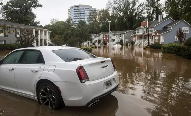 One of several stranded cars is seen at a flooded apartment complex after Hurricane Helene passed the area on Friday, Sept. 27, 2024, in Atlanta. (AP Photo/Ron Harris)