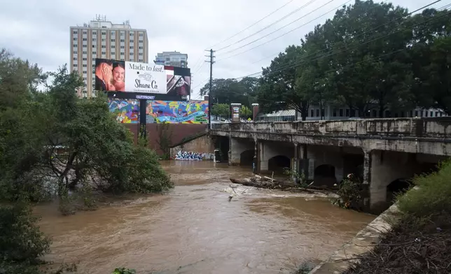 An overpass above a swollen and rushing Peachtree Creek, the site of a major Civil War battle, is seen overflowing its lower banks after Hurricane Helene passed the area on Friday, Sept. 27, 2024, in Atlanta. (AP Photo/Ron Harris)
