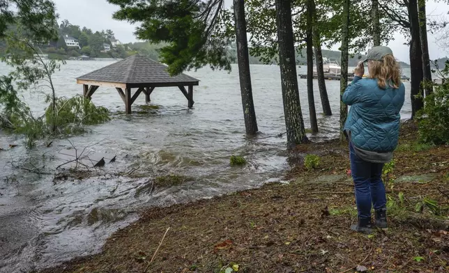 Julie Cioffoletti looks at her flooded gazebo and steps to her dock in her backyard after Hurricane Helene passed the area on Lake James, Friday, Sept. 27, 2024 in Morganton, N.C. (AP Photo/Kathy Kmonicek)