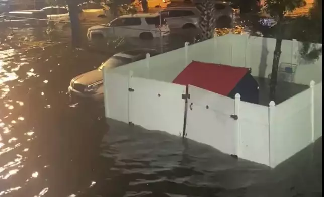 A person looks over a flooded street due to Hurricane Helene late Thursday, Sept. 26, 2024 in New Port Richey, Fla. (Danielle Molisee via AP)