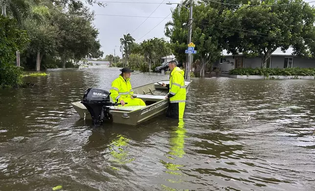 This photo provided by Venice Police Department rescue crews assist residents after conducting door-to-door wellness checks, in coastal areas that were flooded by Hurricane Helene on Friday, Sept. 27, 2024 in Venice, Fla . (Venice Police Department via AP)