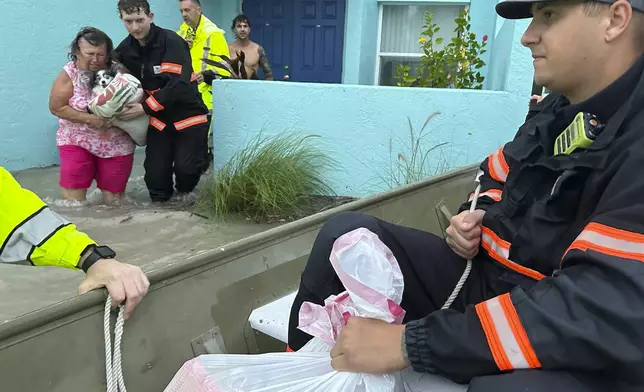 This photo provided by Venice Police Department rescue crews assist residents after conducting door-to-door wellness checks, in coastal areas that were flooded by Hurricane Helene on Friday, Sept. 27, 2024 in Venice, Fla . (Venice Police Department via AP)