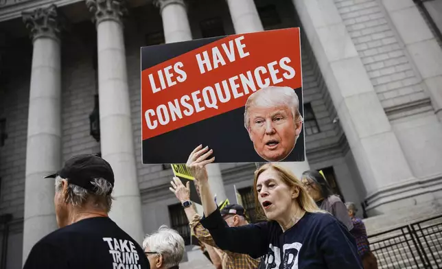 People protest against former President Donald Trump before his arrival to the New York Federal Court, Friday, Sept. 6, 2024, in New York. (AP Photo/Eduardo Munoz Alvarez)