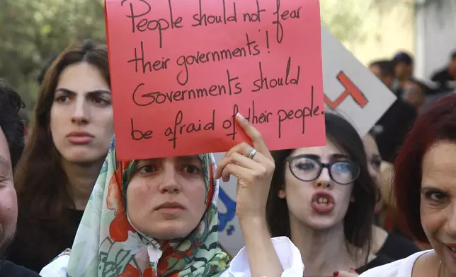 Members of the opposition and civil society groups shout slogans and wave placards during a demonstration against Tunisia president Kais Saied, ahead of the upcoming presidential elections, in Tunis, Friday, Sept. 27, 2024. (AP Photo/Anis Mili)