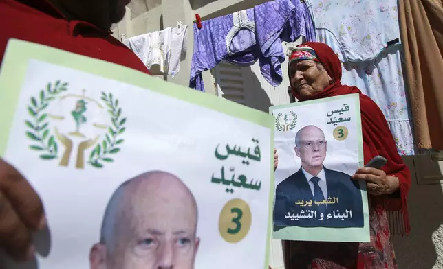 Supporters of Tunisian President and candidate for re-election Kais Saied meet with residents of a neighbourhood during a campaign tour, in Ariana, Tunisia, Thursday, Sept. 26, 2024. (AP Photo/Anis Mili)