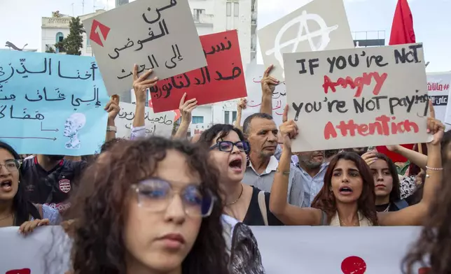 Tunisian take part in a protest against President Kais Saied ahead of the upcoming presidential elections, Friday, Sept. 13, 2024, on Avenue Habib Bourguiba in the capital Tunis. Banner in Arabic reads "Women against dictatorship." (AP Photo/Anis Mili)