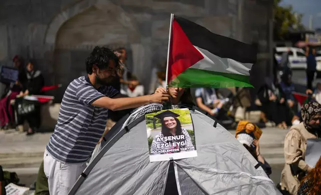 Demonstrators place a Palestinian flag next to a photograph of Aysenur Ezgi Eygi, 26 year-old Turkish-American activist killed by the Israeli military, during a protest in her memory in Istanbul, Turkey, Saturday, Sept. 14, 2024. (AP Photo/Francisco Seco)