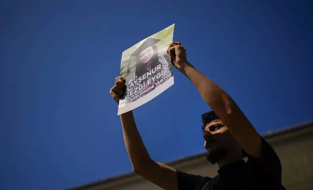 A man holds up a photograph of Aysenur Ezgi Eygi, 26 year-old Turkish-American activist killed by the Israeli military, during a protest in her memory in Istanbul, Turkey, Saturday, Sept. 14, 2024. (AP Photo/Francisco Seco)