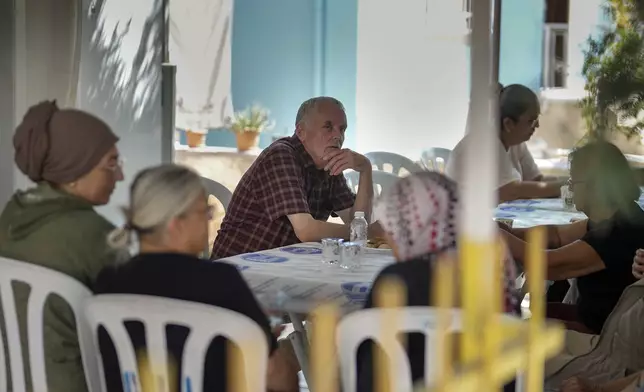 Mehmet, the father of Aysenur Ezgi Eygi, the 26 year-old Turkish-American activist killed by the Israeli military, center, sits with others outside the family house in City of Didim, Turkey, Thursday, Sept. 12, 2024. (AP Photo/Khalil Hamra)