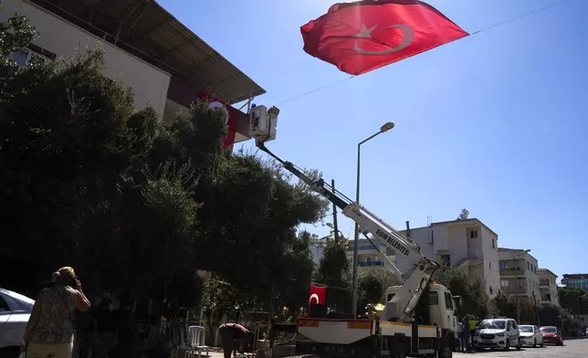 Municipality workers decorate the family house of Aysenur Ezgi Eygi, the 26 year-old Turkish-American activist killed by the Israeli military, with Turkish flags, in City of Didim, Turkey, Thursday, Sept. 12, 2024. (AP Photo/Khalil Hamra)