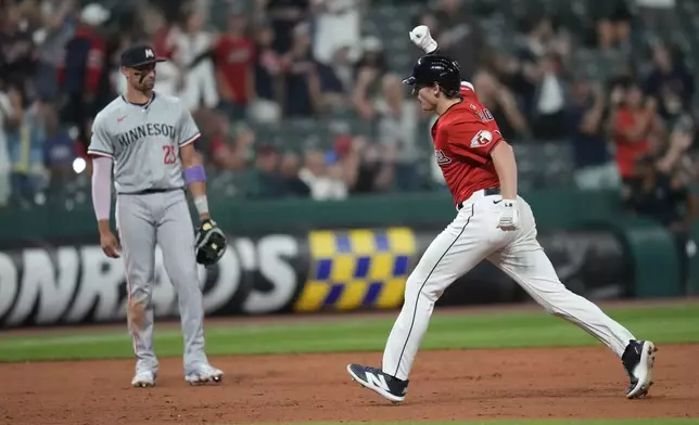 Cleveland Guardians' Kyle Manzardo, right, celebrates as he runs the bases with a home run in the eighth inning of a baseball game against the Minnesota Twins, Monday, Sept. 16, 2024, in Cleveland. Twins' third baseman Royce Lewis is at left. (AP Photo/Sue Ogrocki)