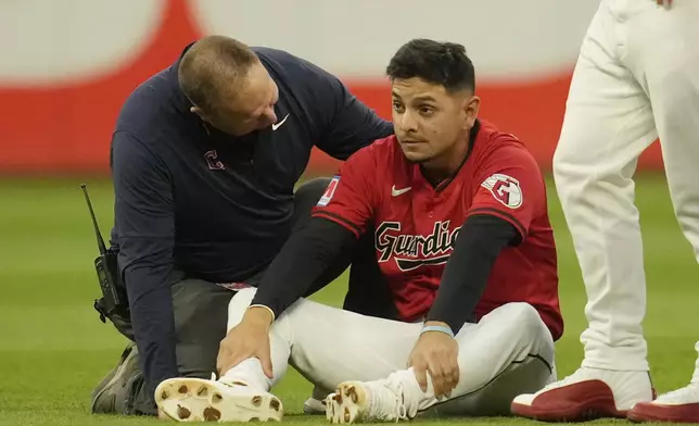 Cleveland Guardians second baseman Andres Gimenez, second from left, is checked out after colliding with second base umpire Chad Fairchild in the third inning of a baseball game against the Minnesota Twins, Monday, Sept. 16, 2024, in Cleveland. (AP Photo/Sue Ogrocki)