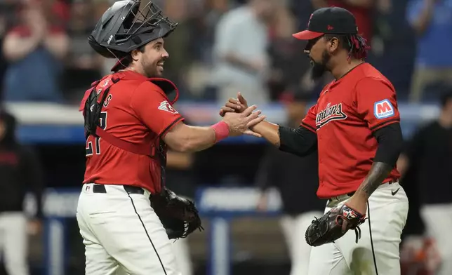 Cleveland Guardians catcher Austin Hedges, left, and relief pitcher Emmanuel Clase, right, celebrate after they defeated the Minnesota Twins in a baseball game Monday, Sept. 16, 2024, in Cleveland. (AP Photo/Sue Ogrocki)