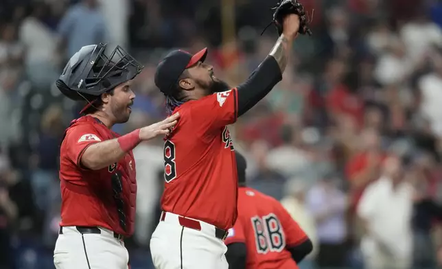 Cleveland Guardians relief pitcher Emmanuel Clase, front right, celebrates with catcher Austin Hedges, left, after they defeated the Minnesota Twins in a baseball game Monday, Sept. 16, 2024, in Cleveland. (AP Photo/Sue Ogrocki)