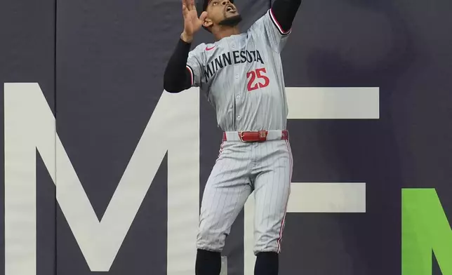 Minnesota Twins center fielder Byron Buxton jumps to catch a fly ball for an out against Cleveland Guardians' Bo Naylor in the second inning of a baseball game Monday, Sept. 16, 2024, in Cleveland. (AP Photo/Sue Ogrocki)