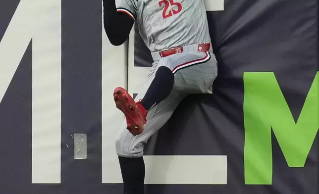 Minnesota Twins center fielder Byron Buxton crashes into the outfield padding after catching a fly ball for an out against Cleveland Guardians' Bo Naylor in the second inning of a baseball game Monday, Sept. 16, 2024, in Cleveland. (AP Photo/Sue Ogrocki)