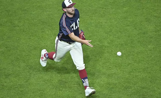 Cleveland Guardians starting pitcher Tanner Bibee tosses to first base to get out Minnesota Twins' Christian Vazquez during the fifth inning of a baseball game, Wednesday, Sept. 18, 2024, in Cleveland. (AP Photo/David Dermer)