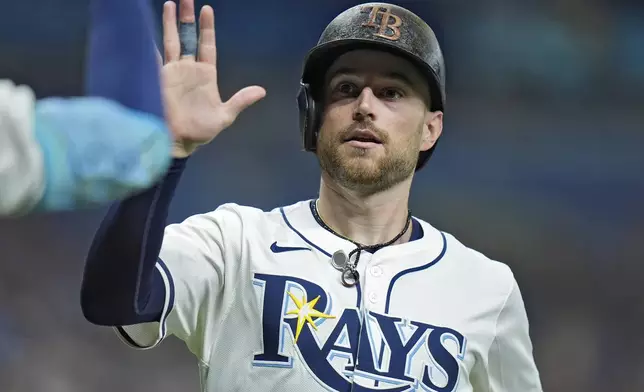 Tampa Bay Rays' Brandon Lowe celebrates after scoring on an RBI double by Junior Caminero off Minnesota Twins starting pitcher Simeon Woods Richardson during the third inning of a baseball game Monday, Sept. 2, 2024, in St. Petersburg, Fla. (AP Photo/Chris O'Meara)