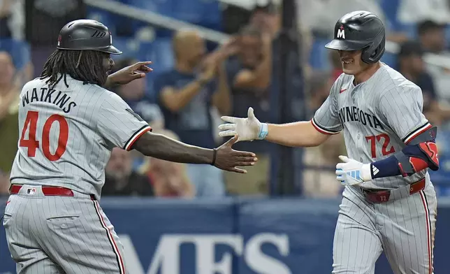 Minnesota Twins' Brooks Lee (72) celebrates with third base coach Tommy Watkins (40) after his solo home run off Tampa Bay Rays relief pitcher Garrett Cleavinger during the eighth inning of a baseball game Monday, Sept. 2, 2024, in St. Petersburg, Fla. (AP Photo/Chris O'Meara)