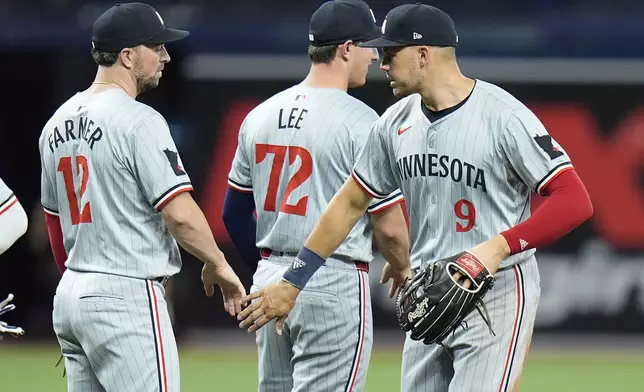 Minnesota Twins' Trevor Larnach (9) celebrates with Brooks Lee (72) and Kyle Farmer (12) after the team defeated the Tampa Bay Rays during a baseball game Monday, Sept. 2, 2024, in St. Petersburg, Fla. (AP Photo/Chris O'Meara)