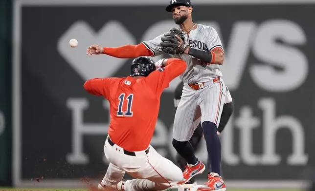 Boston Red Sox's Rafael Devers (11) is forced out at second base as Minnesota Twins second baseman Willi Castro turns the double play on Tyler O'Neill during the fifth inning of a baseball game, Friday, Sept. 20, 2024, in Boston. (AP Photo/Michael Dwyer)