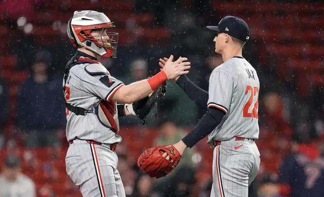 Minnesota Twins pitcher Griffin Jax (22) and catcher Ryan Jeffers, left, celebrate after defeating the Boston Red Sox during the 12th inning of a baseball game, Friday, Sept. 20, 2024, in Boston. (AP Photo/Michael Dwyer)