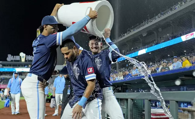 Kansas City Royals' Tommy Pham, center, is doused by MJ Melendez, left, and Bobby Witt Jr. after their baseball game against the Minnesota Twins Friday, Sept. 6, 2024, in Kansas City, Mo. The Royals won 5-0. (AP Photo/Charlie Riedel)