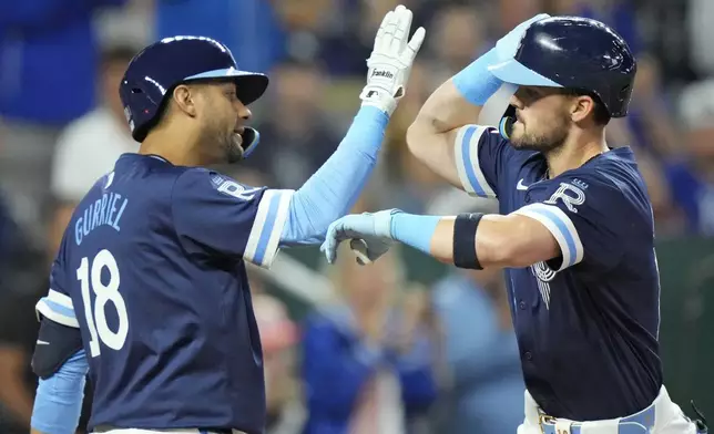 Kansas City Royals' Michael Massey, right, celebrates with Yuli Gurriel (18) after hitting a solo home run during the fourth inning of a baseball game against the Minnesota Twins Friday, Sept. 6, 2024, in Kansas City, Mo. (AP Photo/Charlie Riedel)