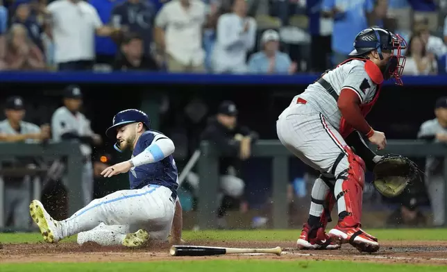 Kansas City Royals' Kyle Isbel beats the tag by Minnesota Twins catcher Christian Vazquez to score on a double by Tommy Pham during the third inning of a baseball game Friday, Sept. 6, 2024, in Kansas City, Mo. (AP Photo/Charlie Riedel)