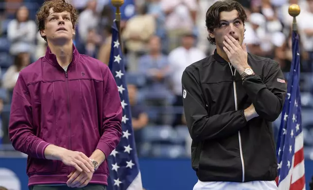 Jannik Sinner, of Italy, and Taylor Fritz, of the United States, listen to comments during the trophy ceremony after Sinner defeated Fritz in the men's singles final of the U.S. Open tennis championships, Sunday, Sept. 8, 2024, in New York. (AP Photo/Julia Nikhinson)