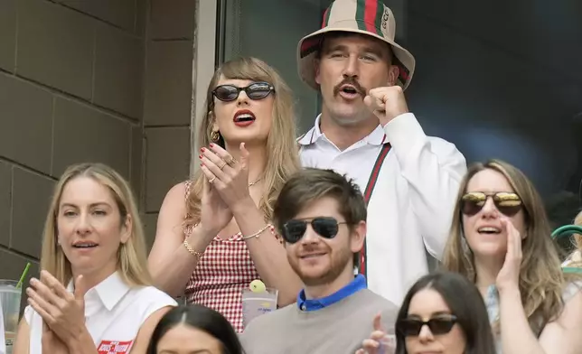 Taylor Swift and Kansas City Chiefs tight end Travis Kelce, cheer as they watch play between Jannik Sinner, of Italy, and Taylor Fritz, of the United States, during the men's singles final of the U.S. Open tennis championships, Sunday, Sept. 8, 2024, in New York. (AP Photo/Seth Wenig)