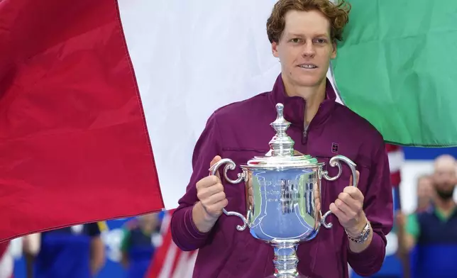 Jannik Sinner, of Italy, holds up the championship trophy after defeating Taylor Fritz, of the United States, in the men's singles final of the U.S. Open tennis championships, Sunday, Sept. 8, 2024, in New York. (AP Photo/Kirsty Wigglesworth)