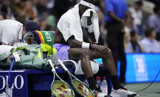 Frances Tiafoe, of the United States, wipes his face between games against Taylor Fritz, of the United States, during the men's singles semifinals of the U.S. Open tennis championships, Friday, Sept. 6, 2024, in New York. (AP Photo/Kirsty Wigglesworth)