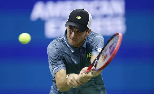 Tommy Paul, of the United States, returns a shot against Jannik Sinner, of Italy, during a fourth round match of the U.S. Open tennis championships, Monday, Sept. 2, 2024, in New York. (AP Photo/Adam Hunger)