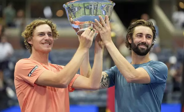 Max Purcell, left, and Jordan Thompson, of Australia, hold up the championship trophy after defeating Tim Puetz and Kevin Krawietz, of Germany in the men's doubles final of the U.S. Open tennis championships, Saturday, Sept. 7, 2024, in New York. (AP Photo/Pamela Smith)