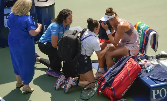 Beatriz Haddad Maia, of Brazil, is checked by medical personnel during the second set against Karolina Muchova, of the Czech Republic, during the quarterfinals of the U.S. Open tennis championships, Wednesday, Sept. 4, 2024, in New York. (AP Photo/Kirsty Wigglesworth)