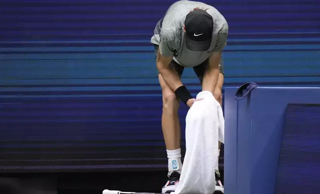 Jannik Sinner, of Italy, holds his left wrist after falling on the court in the second set against Jack Draper, of Great Britain, during the men's singles semifinal of the U.S. Open tennis championships, Friday, Sept. 6, 2024, in New York. (AP Photo/Frank Franklin II)